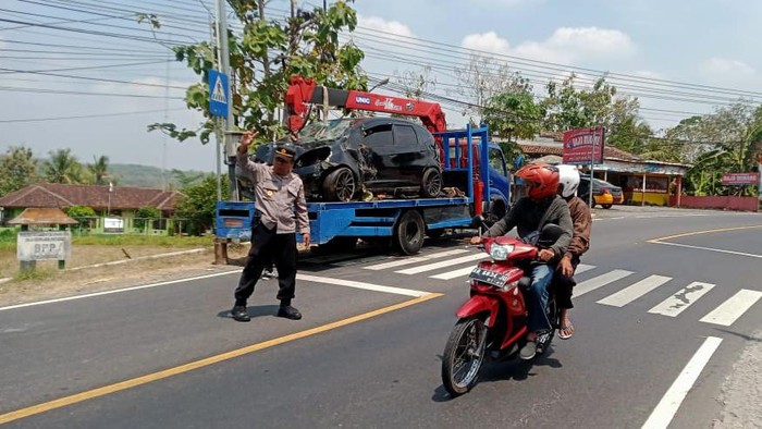 Polisi menderek mobil Honda Jazz AB 1359 SD yang masuk parit di tikungan Tri Sakti, Patuk, Gunungkidul, DIY, Kamis (22/8/2024).