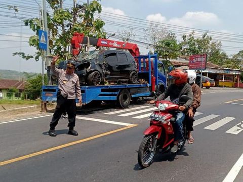 Polisi menderek mobil Honda Jazz AB 1359 SD yang masuk parit di tikungan Tri Sakti, Patuk, Gunungkidul, DIY, Kamis (22/8/2024).