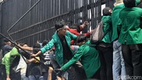 Sejumlah pendemo naik ke pagar dan mencopot sejumlah besinya.