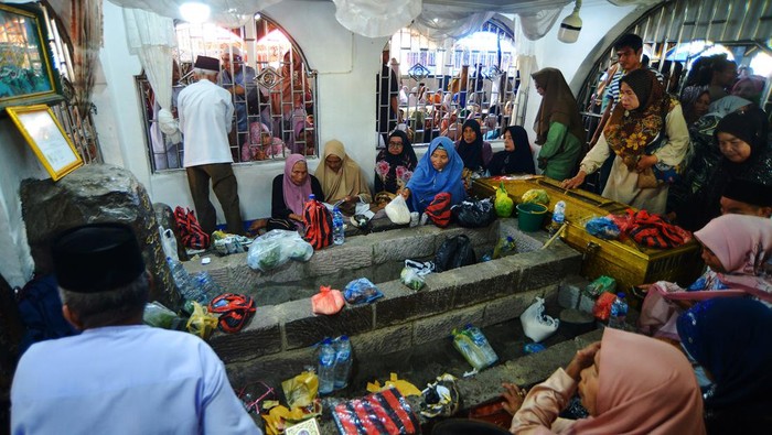 Peziarah memberikan barang bawaan di sisi makam Syekh Burhanuddin saat tradisi Basapa di Ulakan, Padang Pariaman, Sumatera Barat, Rabu (21/8/2024). Jamaah tarekat Syatariah dari Sumatera Barat dan sekitarnya mengikuti tradisi Basapa atau basafar di kawasan Makam Syekh Burhanuddin yang biasa digelar pada Rabu di atas 10 Safar bertepatan dengan wafatnya ulama berpengaruh di Minangkabau itu pada 1116 hijriah.  ANTARA FOTO/Iggoy el Fitra/aww.