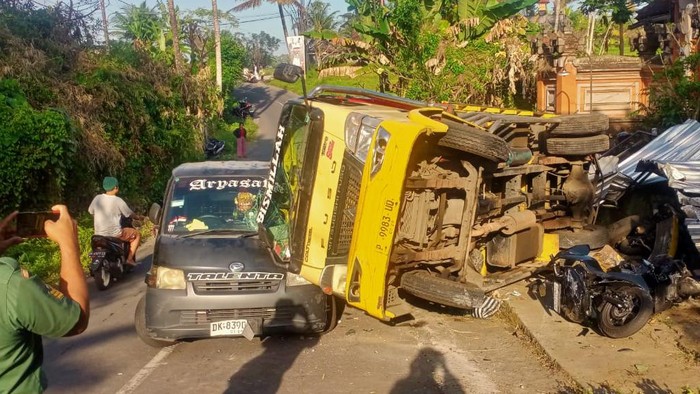 Truk bermuatan kayu terguling dan menimpa pikap dan tiga sepeda motor di Siangan, Gianyar, Kamis (22/8/2024). (dok Polsek Gianyar).