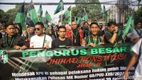 Sejumlah peserta aksi terlihat membawa poster. Poster itu bertulisan Sayang Anak Konstitusi Diinjak hingga Di balik Pria Sukses Ada Bapak di Belakang.