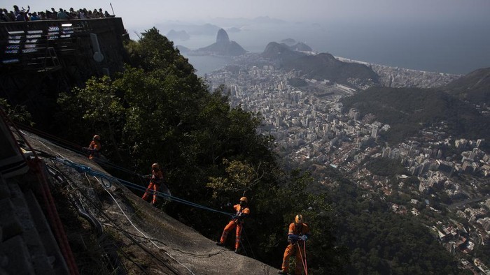 Aksi Petugas Bersihkan Sampah di Lereng Patung Kristus Brasil Trash collectors rappel down Corcovado Mountain to remove garbage dumped on the slope of the Christ the Redeemer Statue in Rio de Janeiro, Thursday, Aug. 22, 2024. (AP Photo/Bruna Prado)