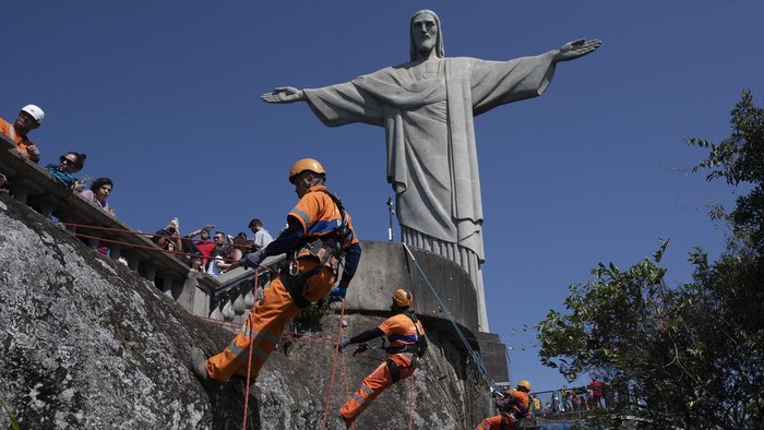 Aksi Petugas Bersihkan Sampah di Lereng Patung Kristus Brasil Trash collectors rappel down Corcovado Mountain to remove garbage dumped on the slope of the Christ the Redeemer Statue in Rio de Janeiro, Thursday, Aug. 22, 2024. (AP Photo/Bruna Prado)