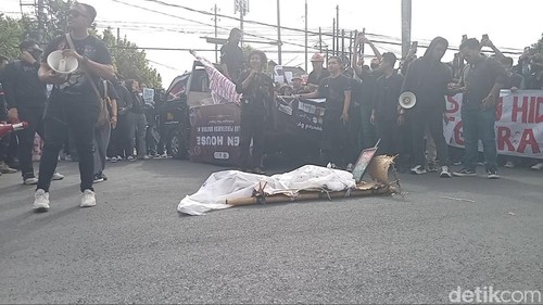 Demonstrasi mahasiswa menolak revisi UU Pilkada dengan membawa keranda jenazah dan diiringi musik angklung ngaben di depan Kampus Unud Sudirman, Denpasar, Jumat (23/8/2024). (Aryo Mahendro/detikBali)