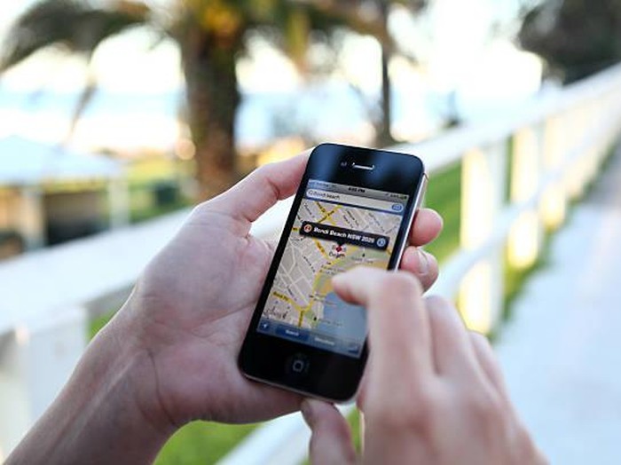 A woman using the application Google Maps on an iPhone.