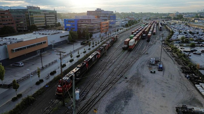 Kereta Api Kanada Mogok Beroperasi Imbas Sengketa Tenaga Kerja A drone view shows a freight train and box cars sitting idle at a Canadian National Railway Co. Yard after the company locked out workers during an ongoing contract dispute in Vancouver, British Columbia, Canada August 22, 2024. REUTERS/Jesse Winter