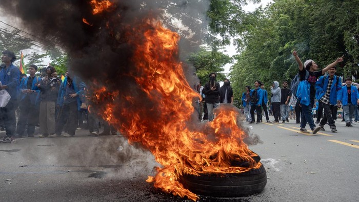 Sejumlah mahasiswa meneriakkan yel-yel di depan ban yang dibakar saat berunjuk rasa di depan kantor DPRD Sulawesi Tengah di Palu, SUlawesi Tengah, Jumat (23/8/2024). Unjuk rasa yang dikuti gabungan mahasiswa di Kota Palu itu merupakan bagian dari gerakan peringatan darurat demokrasi di Indonesia setelah DPR mengabaikan putusan MK dan mereka menyatakan sikap untuk terus mengawalnya. ANTARA FOTO/Basri Marzuki/nym.