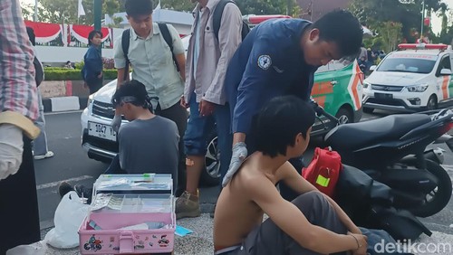 Mahasiswa menderita luka akibat demonstrasi ricuh di depan gedung DPRD NTB, Jumat (23/8/2024) mendapatkan perawatan dari sukarelawan kesehatan. (Ahmad Viqi/detikBali)
