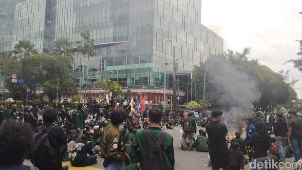 Massa aksi terpantau berkumpul dan duduk di tengah persimpangan empat, tepatnya di depan Lippo Plaza Medan. (Kartika Sari/detikSumut)