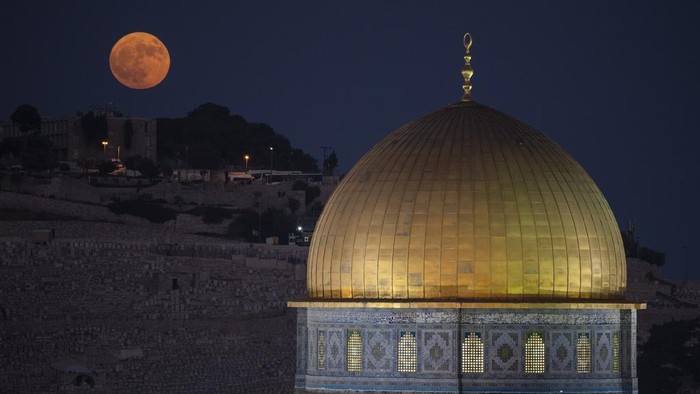 The super moon rises behind the Dome of the Rock shrine at the Al Aqsa Mosque compound in the Old City of Jerusalem, Monday, Aug. 19, 2024. (AP Photo/Leo Correa)