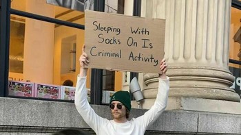Tidur pakai kaus kaki adalah kegiatan kriminal, tulisnya, singkat, padat, jelas. Foto: Instagram/dudewithsign