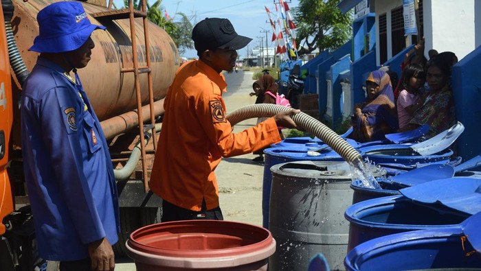 Petugas mengisi air ke dalam wadah saat penyaluran bantuan air bersih di Desa Pajukukang, Kecamatan Bontoa, Kabupaten Maros, Sulawesi Selatan, Jumat (23/8/2024). Pemerintah Kabupaten Maros melalui Badan Penanggulangan Bencana Daerah (BPBD) menyalurkan bantuan air bersih sebanyak 30 ribu liter per hari selama 20 hari ke depan ke daerah-daerah yang terdampak kekeringan. ANTARA FOTO/Hasrul Said/YU/nym.