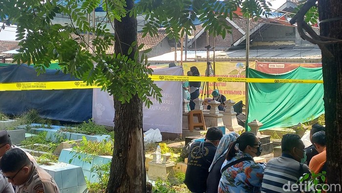 Polisi saat membongkar makam pegawai kantor DPD Perindo Solo VH (42) di TPU Sumber, Kecamatan Banjarsari, Kota Solo, Jumat (23/8/2024).