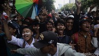 Mereka tampak tertahan oleh barikade dan aparat kepolisian.