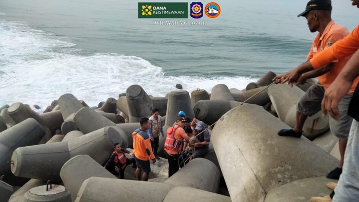 Proses evakuasi pemancing teler yang terjatuh di pemecah ombak Pantai Congot, Temon, Kulon Progo, Jumat (23/8).