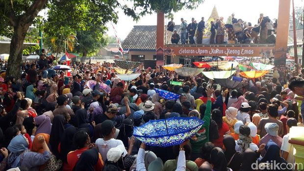 Warga berebut apem kukus keong emas dalam tradisi sebaran apem atau Saparan di Pengging, Banyudono, Boyolali, Jumat (23/8/2024).