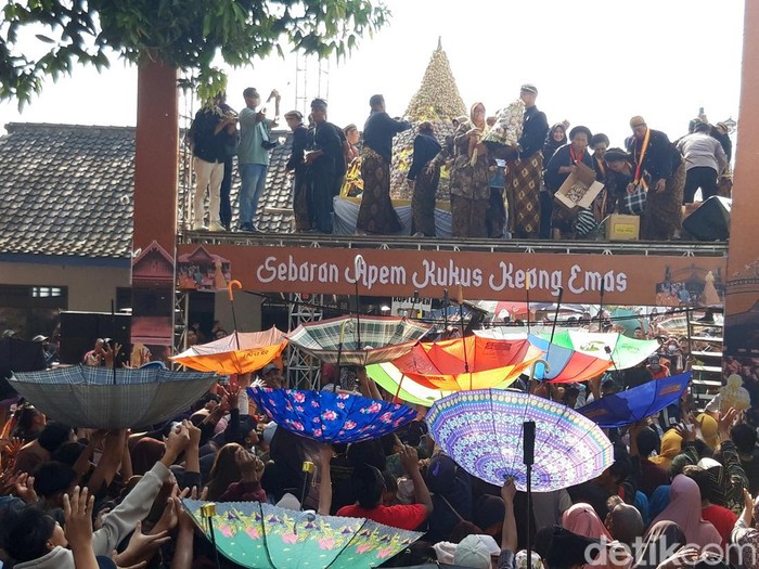 Warga berebut apem kukus keong emas dalam tradisi sebaran apem atau Saparan di Pengging, Banyudono, Boyolali, Jumat (23/8/2024).