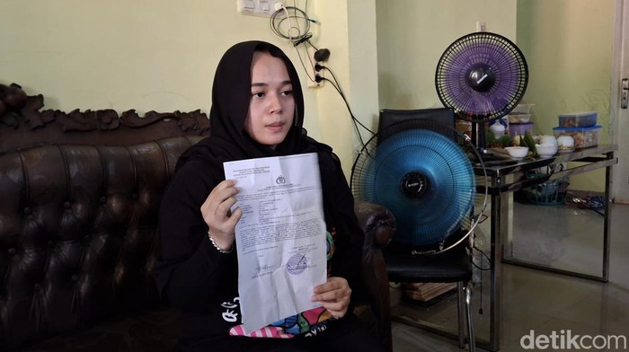 Yora ibu korban saat menunjukan berkas laporan polisi