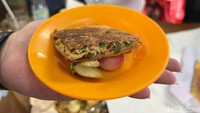 Ini penampakan martabak pakai 4 telur ayam. Martabaknya unik karena masih dibungkus kertas dan penyajiannya pakai acar. Foto: Detikcom / Atiqa Rana