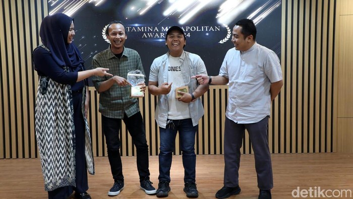 Senior Officer III Media Communication PT Pertamina Elok Riani Ariza (kiri), dan Kepala Bidang Komunikasi Publik Diskominfotik DKI Jakarta Koharudin (kanan) berbincang usai memberikan anugerah Pertamina Megapolitan Award 2024 kepada Pradita Utama (kedua kanan) dan Eusebio Chrysnamurti dalam rangkaian pameran Rekam Jakarta 2024 di Perpustakaan Taman Ismail Marzuki, Jakarta, Jumat (23/8/2024).