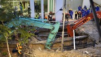 Petugas penyelamat memasuki lubang pembuangan yang dalam di Kuala Lumpur setelah menerima laporan bahwa seorang wanita terjatuh setelah bagian trotoar ambruk pada tanggal 23 Agustus 2024.