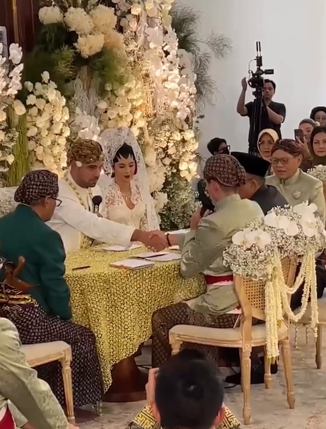 Riasan wajah Nadine juga tidak kalah menarik perhatian. Ia mengenakan paes ageng riasan khas Yogyakarta yang memberikan sentuhan sakral dan elegan pada penampilannya. Sementara itu Geoffrey tampil gagah dengan mengenakan beskap putih. Tidak lupa, ia juga mengenakan blangkon. Foto: Instagram: @ericktohir