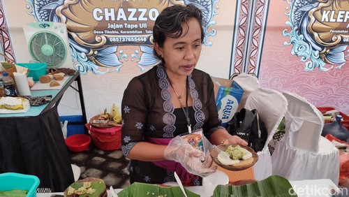 Ni Wayan Suarnadi (51), menyajikan kuliner khas Bali uli tape saat Tanah Lot Art and Festival 2024, Tabanan, Minggu (25/8/2024). (Ahmad Firizqi Irwan/detikBali)