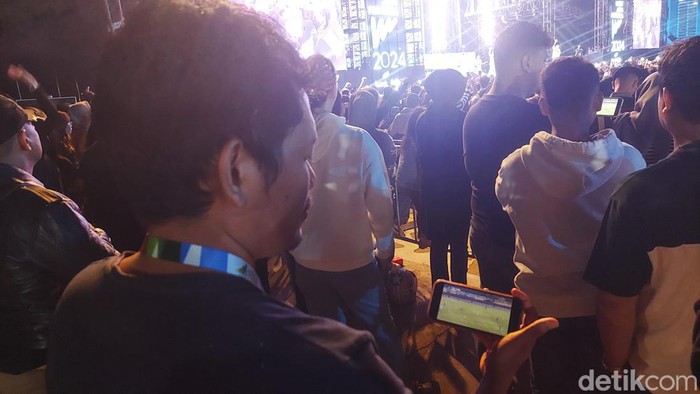 Penonton West Java Festival (WJF) 2024 Nonton Pertandingan Persib dari ponsel