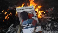 Dalam aksinya, massa sempat membakar berbagai spanduk, melempar botol plastik ke dalam pagar, membawa poster tuntutan dan berorasi.