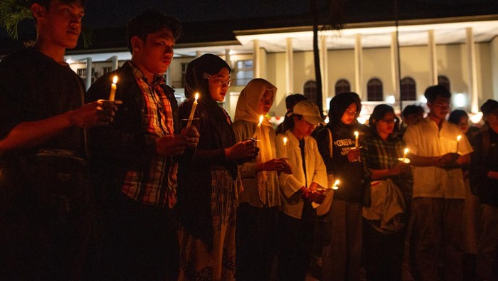 Sejumlah mahasiswa menyalakan lilin di bawah pohon bodhi di Balairung Universitas Gadjah Mada, Sleman, DI Yogyakarta, Senin (26/8/2024). Aksi yang digelar oleh civitas akademika UGM tersebut untuk mengingatkan kembali UGM sebagai institusi yang didirikan untuk melahirkan pengetahuan yang berkeadilan dan mensejahterakan bangsa serta bentuk keprihatinan proses demokrasi di Indonesia. ANTARA FOTO/Hendra Nurdiyansyah/nym.