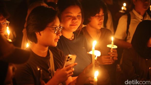 Civitas akademika UGM menggelar aksi dengan menyalakan lilin di bawah pohon bodhi, di depan Balairung UGM Senin (26/8/2024)