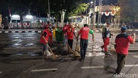 Saat ini petugas tengah menyapu jalanan usai situasi lengang. Terlihat sisa sampah seperti gelas plastik, botol air mineral, hingga bungkus rokok masih berserakan di jalanan.