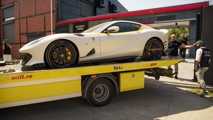 Deretan Mobil Mewah Disita dari Rumah Influencer Kontroversial Andrew Tate Masked police officers walk backdropped by sports cars at Andrew Tate's residence on the outskirts of Bucharest, Romania, Saturday, Aug. 24, 2024. (AP Photo/Vadim Ghirda)