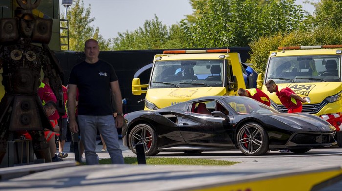 Deretan Mobil Mewah Disita dari Rumah Influencer Kontroversial Andrew Tate Masked police officers walk backdropped by sports cars at Andrew Tate's residence on the outskirts of Bucharest, Romania, Saturday, Aug. 24, 2024. (AP Photo/Vadim Ghirda)
