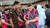 Petugas kejaksaan memakaikan rompi tahanan kepada Emil Ermindra usai sidang.  