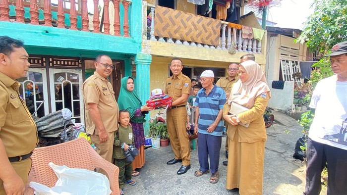 Kepala Dinas Pendidikan Kota Palembang, Adrianus Amri, memberikan bantuan kepada korban kebakaran.