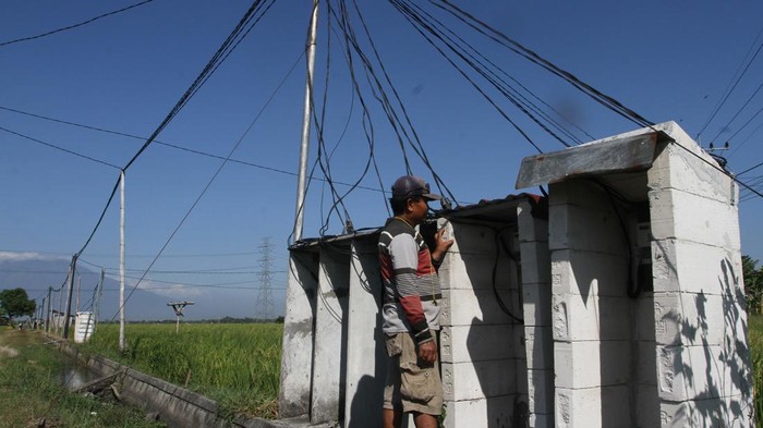 Listrik masuk sawah di Ngawi Petani memeriksa instalasi jaringan listrik yang digunakan untuk mengalirkan air melalui pompa sumur submersibel dalam program Listrik Masuk Sawah di Dawu, Ngawi, Jawa Timur, Senin (26/8/2024). Kementerian Pertanian mencatat dari pemanfaatan program tersebut sebanyak 17.000 lebih unit pompa sumur submersibel telah dipasang dan digunakan petani setampat untuk mengaliri lahan sawah tadah hujan dan mampu menanam padi tiga kali dalam setahun bahkan saat musim kemarau sehingga meningkatkan produktivitas pertanian. ANTARA FOTO/Ari Bowo Sucipto/foc.