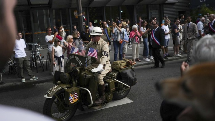 A reenactor parades in a vintage military bike as he celebrates the liberation of Paris from Nazi occupation 80 years ago, in Paris, Sunday, Aug. 25, 2024. People dressed in World War II-era military uniforms and dresses are parading in southern Paris, retracing the entry of French and U.S. tanks into the city on Aug. 25, 1944. (AP Photo/Thibault Camus)