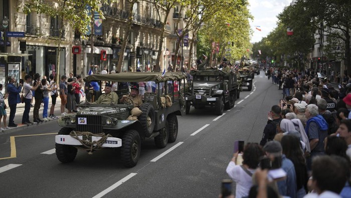 A reenactor parades in a vintage military bike as he celebrates the liberation of Paris from Nazi occupation 80 years ago, in Paris, Sunday, Aug. 25, 2024. People dressed in World War II-era military uniforms and dresses are parading in southern Paris, retracing the entry of French and U.S. tanks into the city on Aug. 25, 1944. (AP Photo/Thibault Camus)