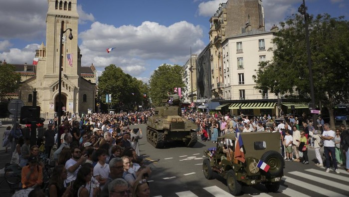 A reenactor parades in a vintage military bike as he celebrates the liberation of Paris from Nazi occupation 80 years ago, in Paris, Sunday, Aug. 25, 2024. People dressed in World War II-era military uniforms and dresses are parading in southern Paris, retracing the entry of French and U.S. tanks into the city on Aug. 25, 1944. (AP Photo/Thibault Camus)