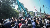 Pantauan detikcom di lokasi, Senin (26/8/2024), warga berteriak di depan alat berat. Mereka meminta seluruh bangunan dibongkar tanpa terkecuali.  