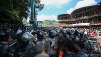 Warga mengarahkan alat berat agar membongkar salah satu restoran besar di lokasi. Mereka menyuruh pengendara alat berat untuk berbelok ke arah restoran.  