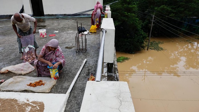 People move a cart with a woman and a child through a flooded street, amid severe flooding in the Fazilpur area of Feni, Bangladesh, August 26, 2024. REUTERS/Mohammad Ponir Hossain