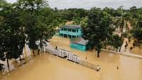 Sebuah pemandangan menunjukkan sekolah dan madrasah yang sebagian terendam di tengah banjir parah di daerah Fazilpur, Feni, Bangladesh, Senin (26/8/2024). Banjir parah terjadi di kota Bangladesh timur, saat hujan monsun terus membanjiri sebagian negara Asia Selatan tersebut.