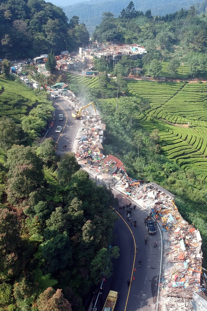 Petugas menggunakan alat berat melakukan pembongkaran bangunan lapak Pedagang Kaki Lima (PKL) di kawasan wisata Puncak, Cisarua, Kabupaten Bogor, Jawa Barat, Senin (26/8/2024). Pemerintah Kabupaten Bogor mengerahkan 1.200 personel gabungan untuk melakukan penertiban 196 bangunan liar di kawasan Puncak, dan pembongkaran lapak PKL tersebut dilaksanakan sebagai penataan kawasan wisata Puncak tahap dua. ANTARA FOTO/Yulius Satria Wijaya/foc.