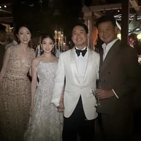 Untuk acara resepsi Clarissa kembali tampil cantik dan anggun mengenakan tube dress berwarna putih. Gaun dengan motif 3D itu dipadukan dengan sepasang anting mewah model raindrop dan kalung. Foto: Instagram/@angelina1901