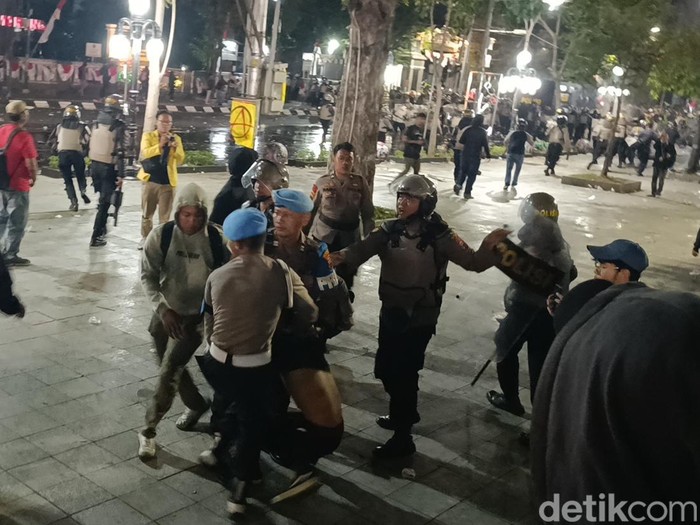 Polisi mengamankan massa yang terlibat dalam unjuk rasa berujung ricuh di depan Balai Kota Semarang, Senin (21/8/2024) malam.