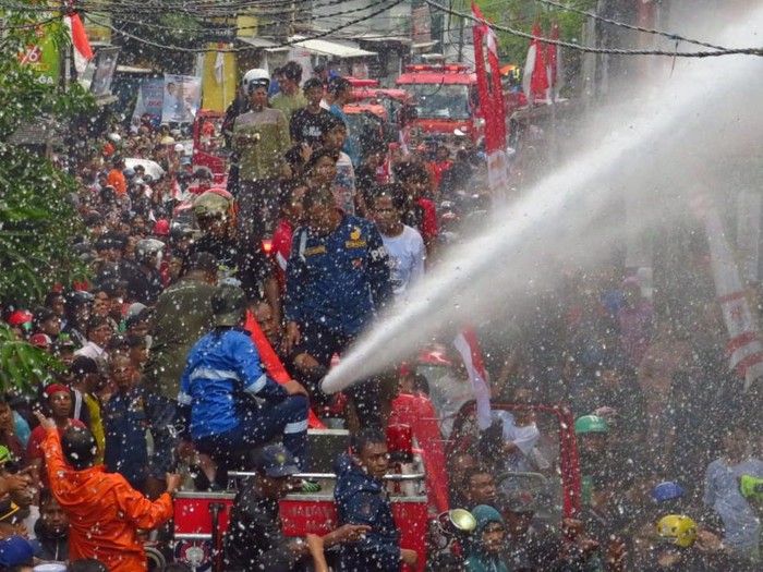 Potret Damkar Makassar padamkan kebakaran di Pelabuhan Paotere di tengah desakan warga. Dokumen Istimewa