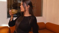 Ria juga memamerkan pose elegan saat menikmati secangkir kopi. Ia menuliskan keterangan, Sipping (emoticon kopi). Foto: Instagram @ria.travelwithmeri
